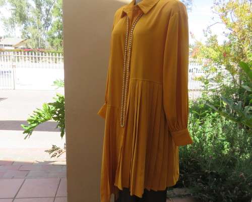 Uniquely styled long mustard top.Silky polyester.Button down.Right side longer.Size 38/40.As new
