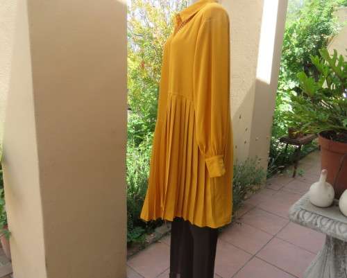Uniquely styled long mustard top.Silky polyester.Button down.Right side longer.Size 38/40.As new
