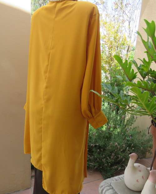 Uniquely styled long mustard top.Silky polyester.Button down.Right side longer.Size 38/40.As new