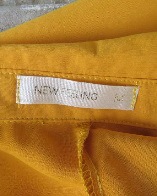 Uniquely styled long mustard top.Silky polyester.Button down.Right side longer.Size 38/40.As new