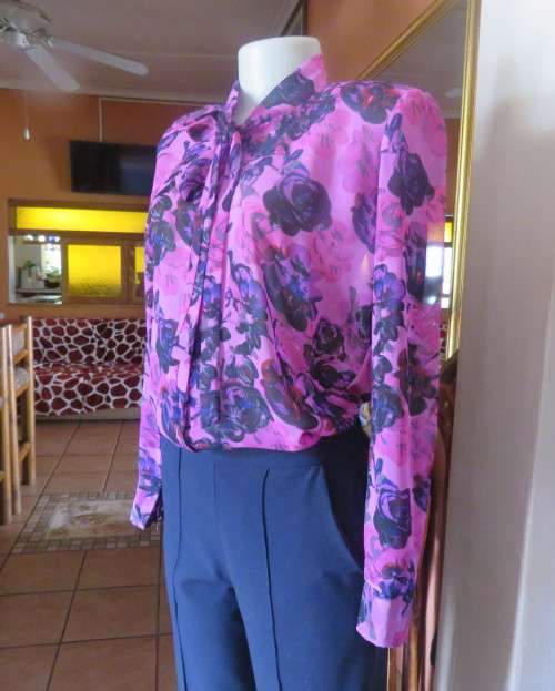Eyecatching pink/purple floral long sleeve blouse.Hidden button down front and tie collar.Size36/12