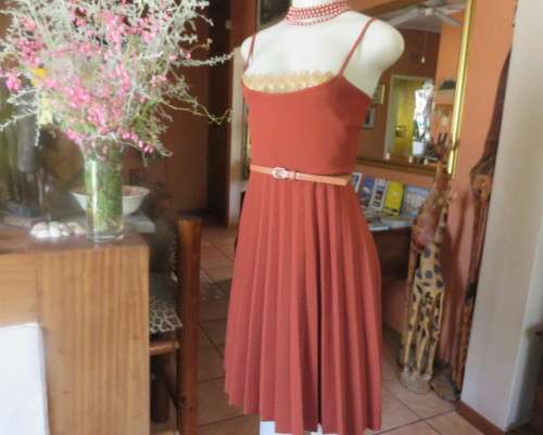 Sweet brick colour size 32 dress with permanent pleated bottom.Strappy top/lace decoration.As new
