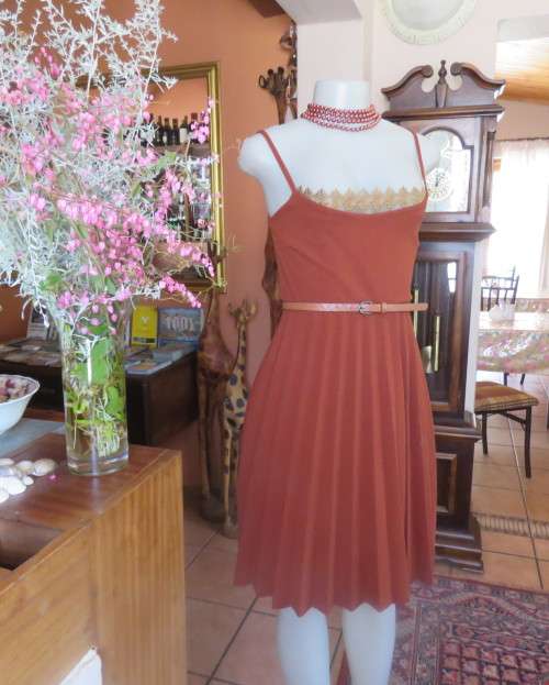 Sweet brick colour size 32 dress with permanent pleated bottom.Strappy top/lace decoration.As new