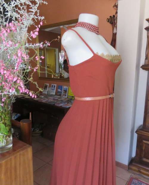 Sweet brick colour size 32 dress with permanent pleated bottom.Strappy top/lace decoration.As new