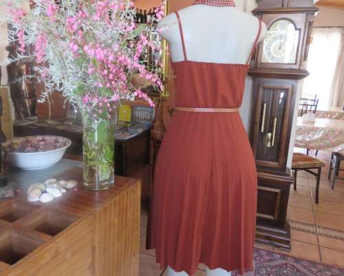 Sweet brick colour size 32 dress with permanent pleated bottom.Strappy top/lace decoration.As new