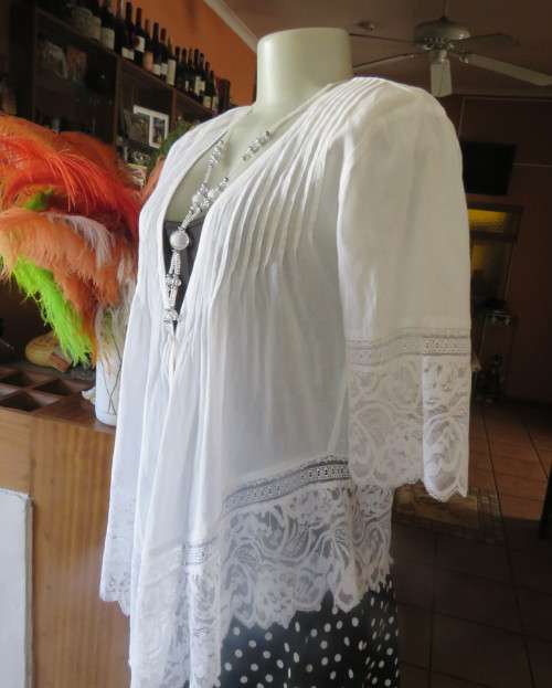 Dainty fine cotton waterfall style white top.Tuckking and lace decoration.One button closure.Size 36