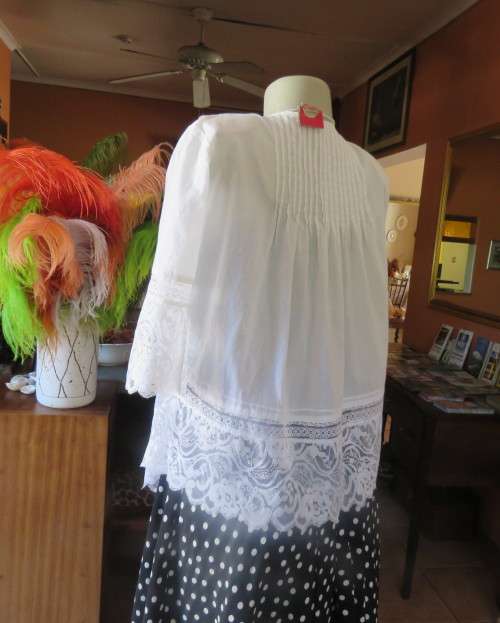 Dainty fine cotton waterfall style white top.Tuckking and lace decoration.One button closure.Size 36