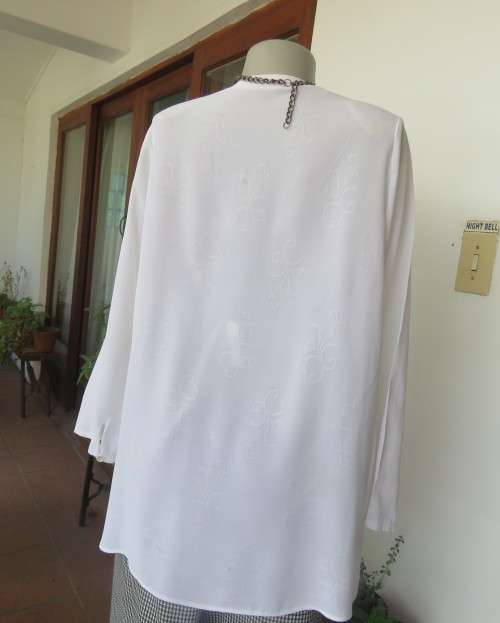 Embossed white loose cut button down V neck top with long sleeves.Size large 40. As new in polyester