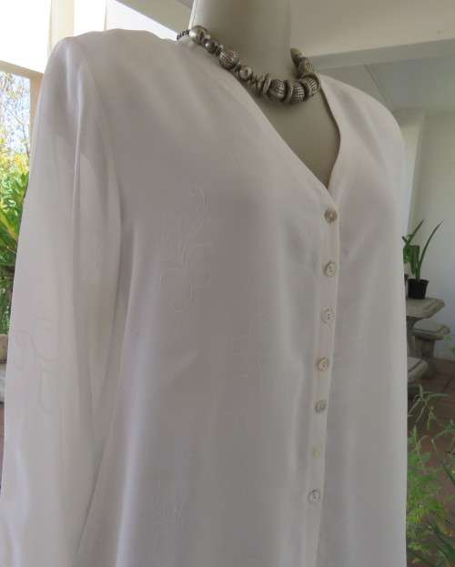 Embossed white loose cut button down V neck top with long sleeves.Size large 40. As new in polyester