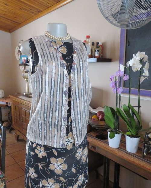 Spice up your outfit with this glamour sleeveless open hanging top.Richly decorated.Size 36.As new.