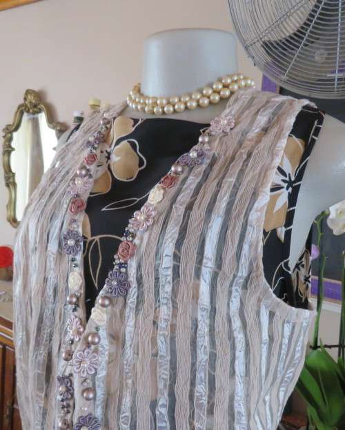 Spice up your outfit with this glamour sleeveless open hanging top.Richly decorated.Size 36.As new.