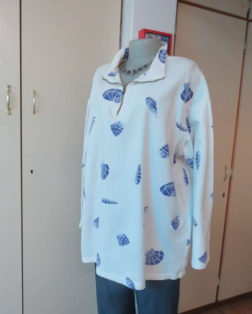 Warm long sleeve white slip over top with blue shells.Zip up front opening and high collar.Size XL