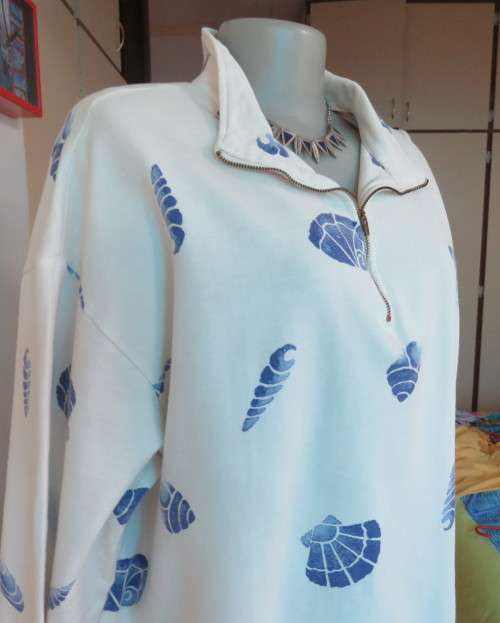 Warm long sleeve white slip over top with blue shells.Zip up front opening and high collar.Size XL