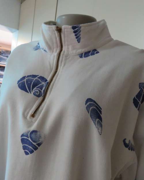Warm long sleeve white slip over top with blue shells.Zip up front opening and high collar.Size XL