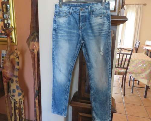 INDIGO USA Denim Co. Men`s jeans with skinny legs in distressed look. Size 34.Close with buttons.