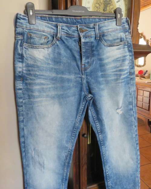 INDIGO USA Denim Co. Men`s jeans with skinny legs in distressed look. Size 34.Close with buttons.