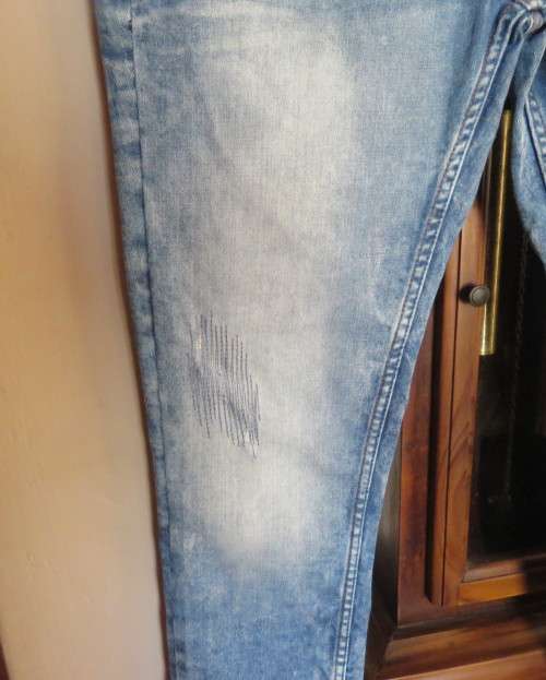 INDIGO USA Denim Co. Men`s jeans with skinny legs in distressed look. Size 34.Close with buttons.