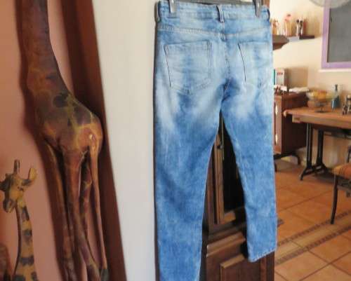 INDIGO USA Denim Co. Men`s jeans with skinny legs in distressed look. Size 34.Close with buttons.