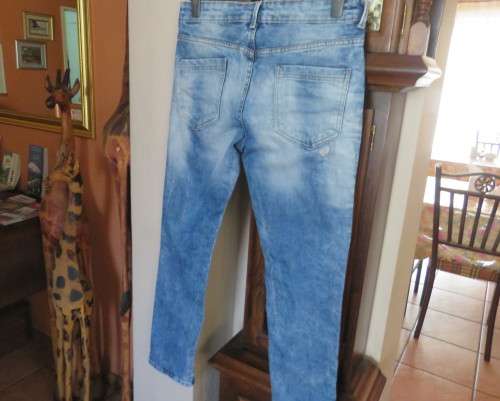 INDIGO USA Denim Co. Men`s jeans with skinny legs in distressed look. Size 34.Close with buttons.