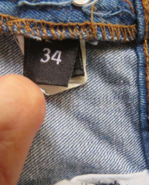 INDIGO USA Denim Co. Men`s jeans with skinny legs in distressed look. Size 34.Close with buttons.