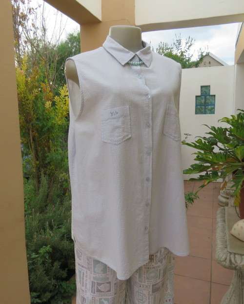 Cool pale blue sleeveless bubble cotton top with button down front.Size 40 to 42.Two cute pockets.