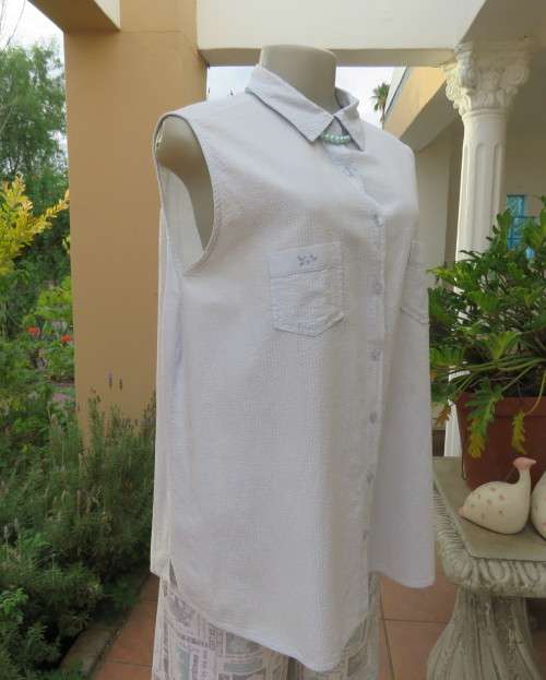 Cool pale blue sleeveless bubble cotton top with button down front.Size 40 to 42.Two cute pockets.