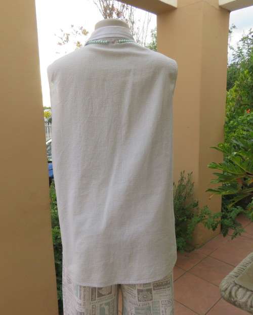 Cool pale blue sleeveless bubble cotton top with button down front.Size 40 to 42.Two cute pockets.