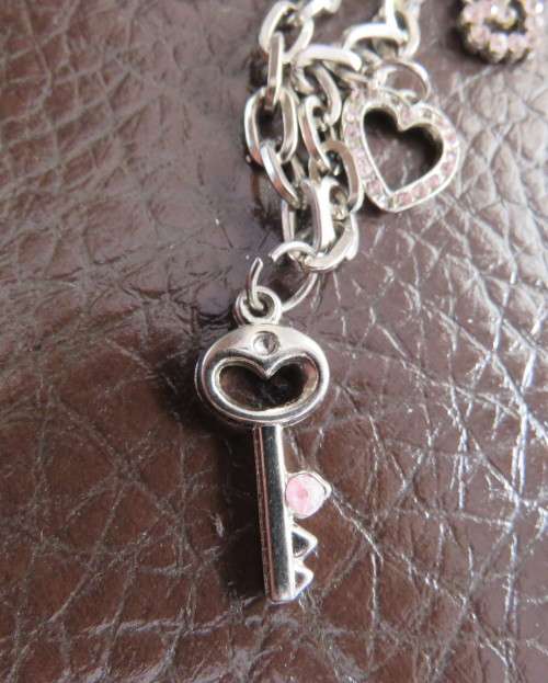 Cute chain bracelet with 3 hearts and 1 small key.With pinkish stones. Length 18cm.As new.