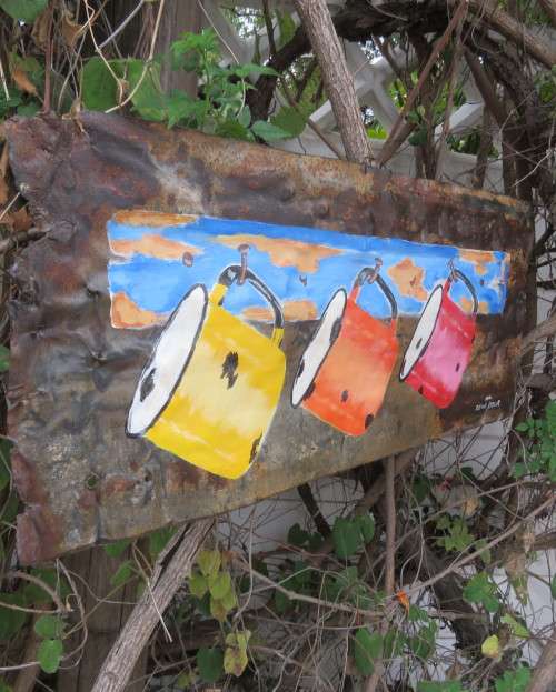 Interesting junk art by DEON ASSUR 2012. Painting of 3 enamel mugs on rusted plate.Size 58 x 25cm.