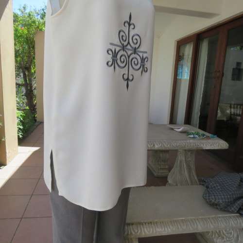 High quality long textured cream polyester top. Sleeveless. Exotic silver front embroidery. Size 36