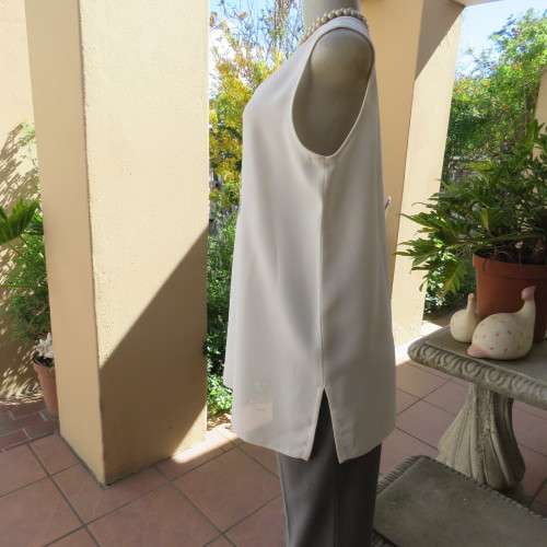 High quality long textured cream polyester top. Sleeveless. Exotic silver front embroidery. Size 36