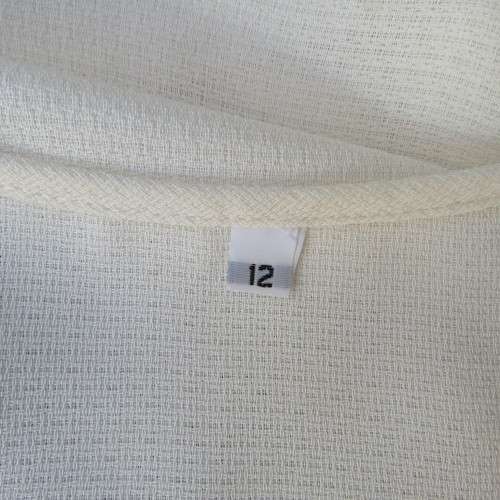 High quality long textured cream polyester top. Sleeveless. Exotic silver front embroidery. Size 36