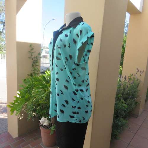 Cool sleeveless sheer turquoise poly top with black brush marks/collar/hidden button down.Size 36/12