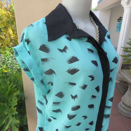 Cool sleeveless sheer turquoise poly top with black brush marks/collar/hidden button down.Size 36/12