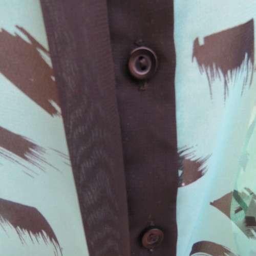 Cool sleeveless sheer turquoise poly top with black brush marks/collar/hidden button down.Size 36/12