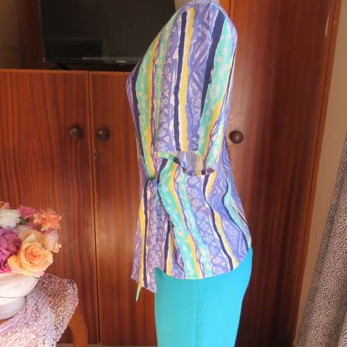 Beautiful fold over 80`s top in 100% viscose. Blue/green/yellow pattern stripes. Ties at side. 36