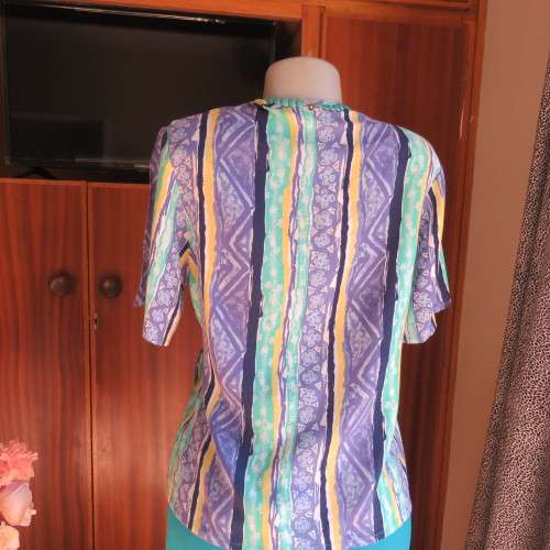 Beautiful fold over 80`s top in 100% viscose. Blue/green/yellow pattern stripes. Ties at side. 36