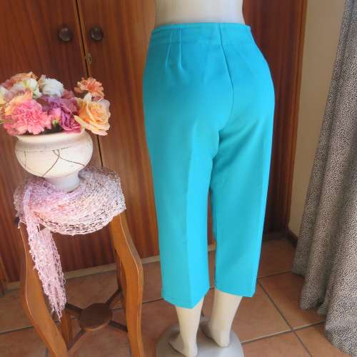 Capri style green jade boutique made polyester pants.High waist with side zip. Size 36/12. New cond.