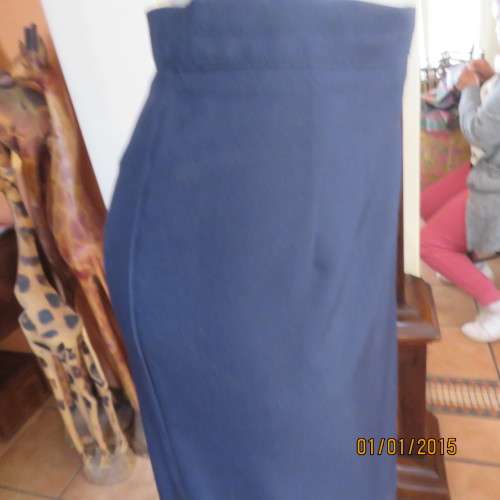Elegant dark navy polyester pencil skirt. Upper calf length. Zip/pleat at back. Size 42 to 44.As new