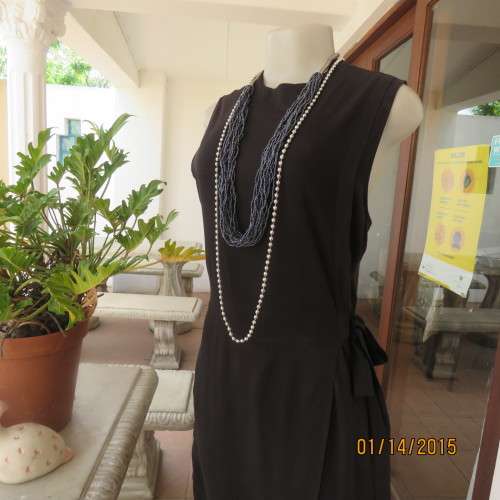 Elegant modern black jumpsuit with foldover skirt front. In 100% rayon.High collar.Size 38/14.As new