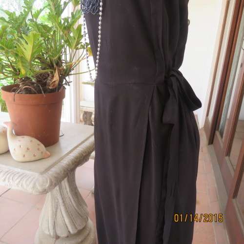 Elegant modern black jumpsuit with foldover skirt front. In 100% rayon.High collar.Size 38/14.As new