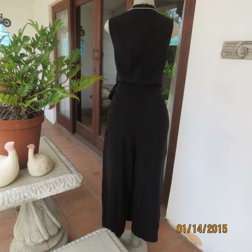 Elegant modern black jumpsuit with foldover skirt front. In 100% rayon.High collar.Size 38/14.As new