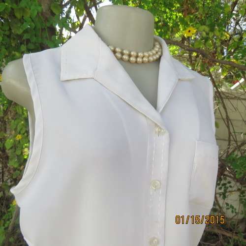 Cool sleeveless summer top in cream polyester. Pretty embroidery on collar and front.Size 36. As new