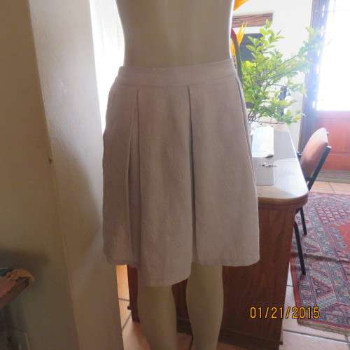 Charming light grey floral embossed poly/nylon knee length skirt.Size 36. Inverted front pleats.