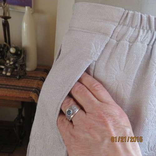 Charming light grey floral embossed poly/nylon knee length skirt.Size 36. Inverted front pleats.