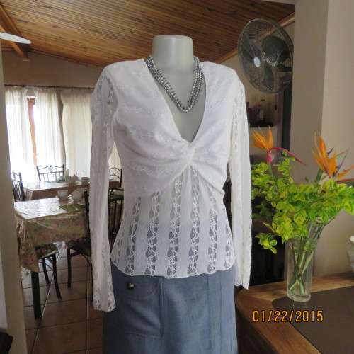 Attractive acrylic stretch lace pull over long sleeve cream top.Knot in center of lined bust.Size 37