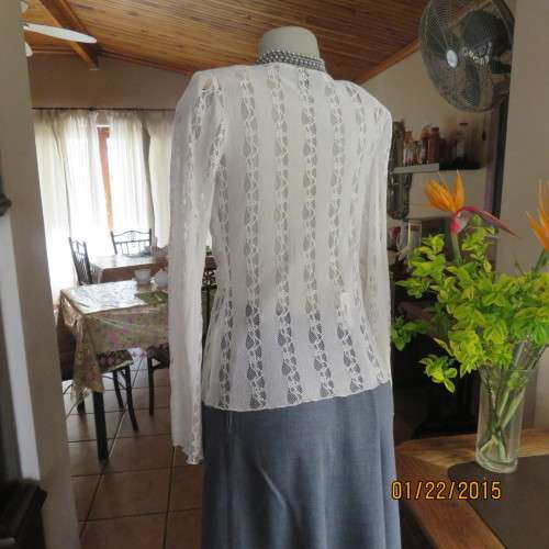 Attractive acrylic stretch lace pull over long sleeve cream top.Knot in center of lined bust.Size 37