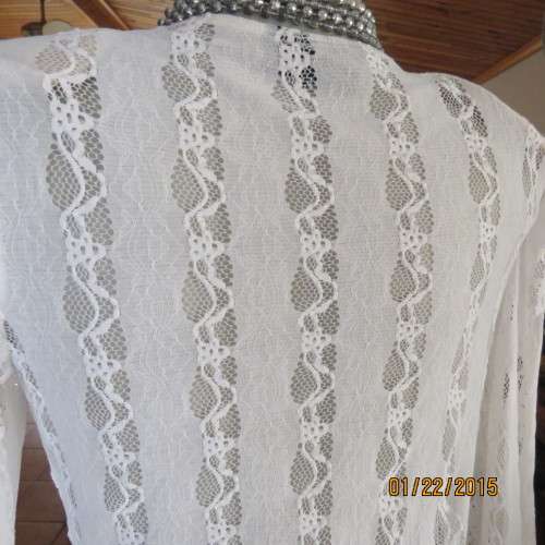 Attractive acrylic stretch lace pull over long sleeve cream top.Knot in center of lined bust.Size 37