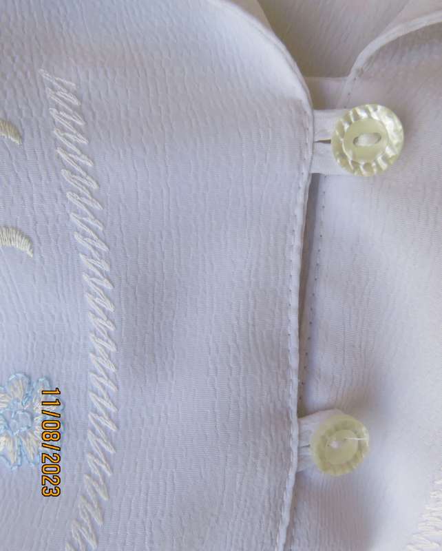 white sleeveless summer top with dainty blue/white embroidery. Size 42