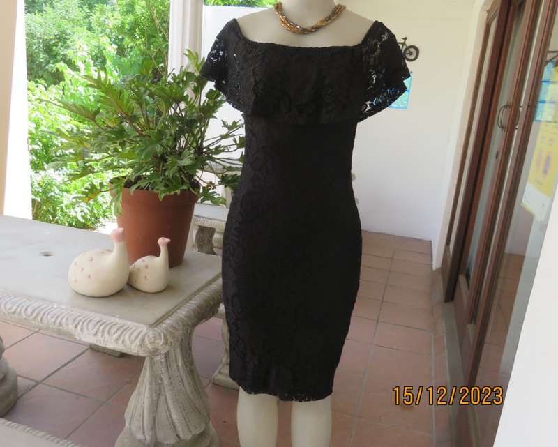 The little black poly/nylon lace dress. Lining stretch poly. Off shoulder/frilled neckline.Size 32